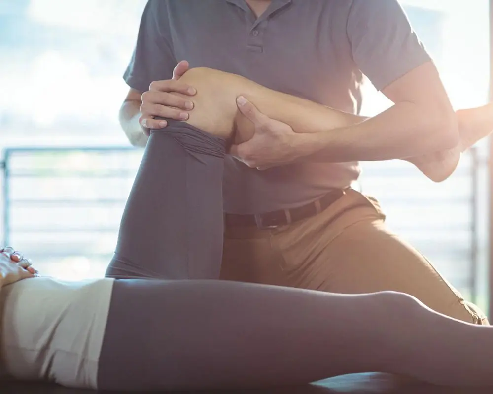 A person sitting on the ground with their hands in front of them.