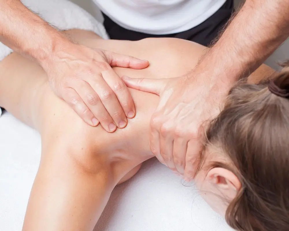 A person is getting their back examined by an osteopath.