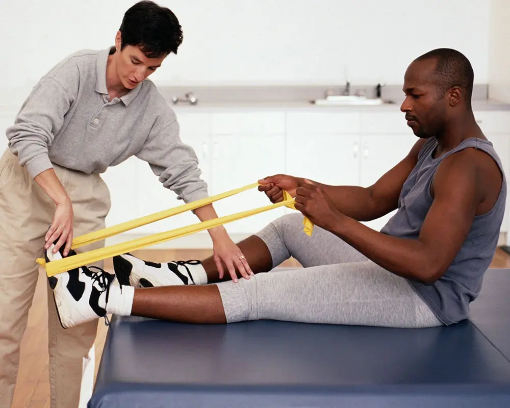 A man is helping another man with his foot.