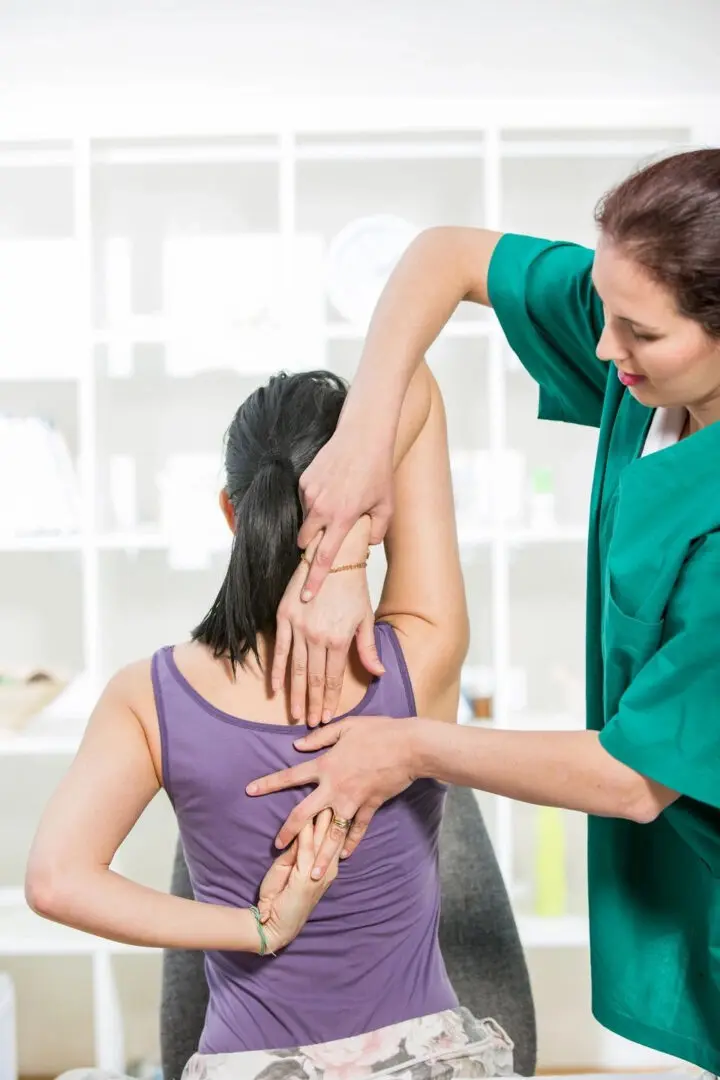 A woman is getting her neck examined by a doctor.