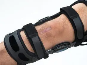 A person wearing an elbow brace with one band around the knee.