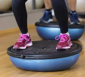 A person is standing on an exercise ball.