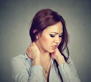 A woman with her hands on the neck of someone.